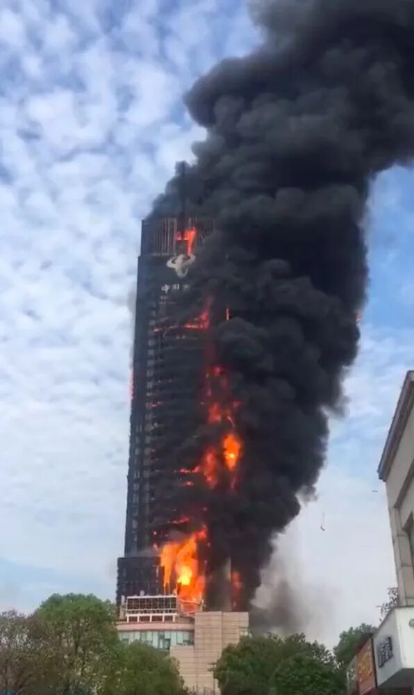 Горит небоскреб. Пожар небоскреба в Китае. Горящие здания. Сгоревшее здание. Пожар в небоскребе.