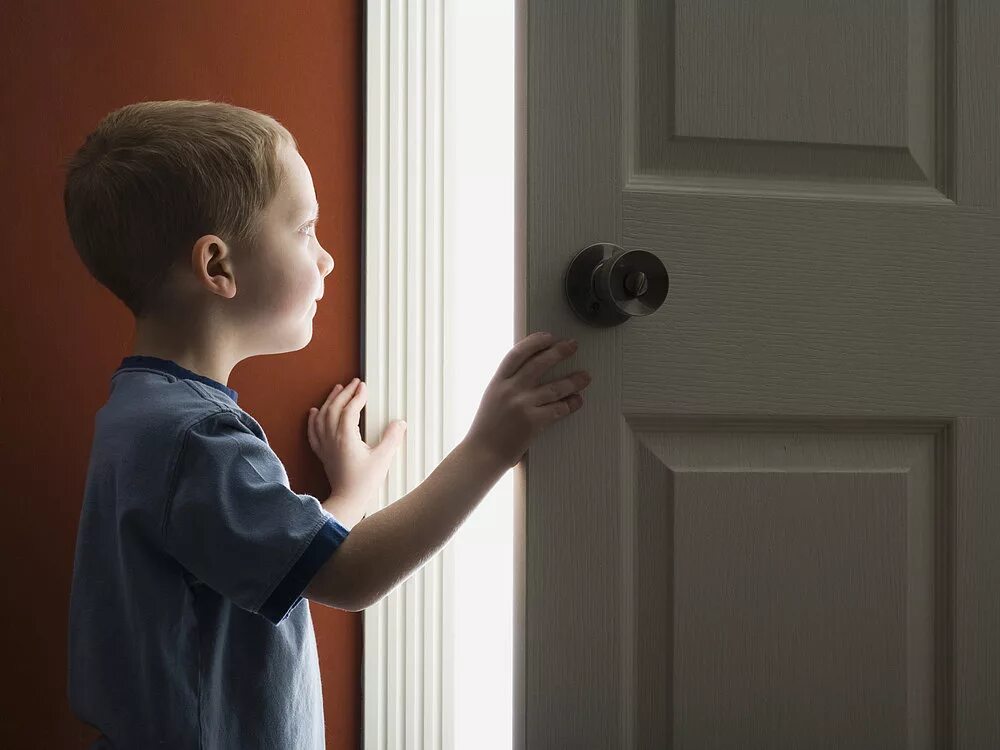 Spying. Мальчик открывает дверь. Ребенок открывает дверь. Приоткрыть дверь. Человек у двери.