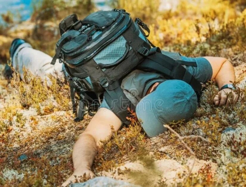 Уставший турист в горах. Уставши турист. Рюкзак валяется на земле.