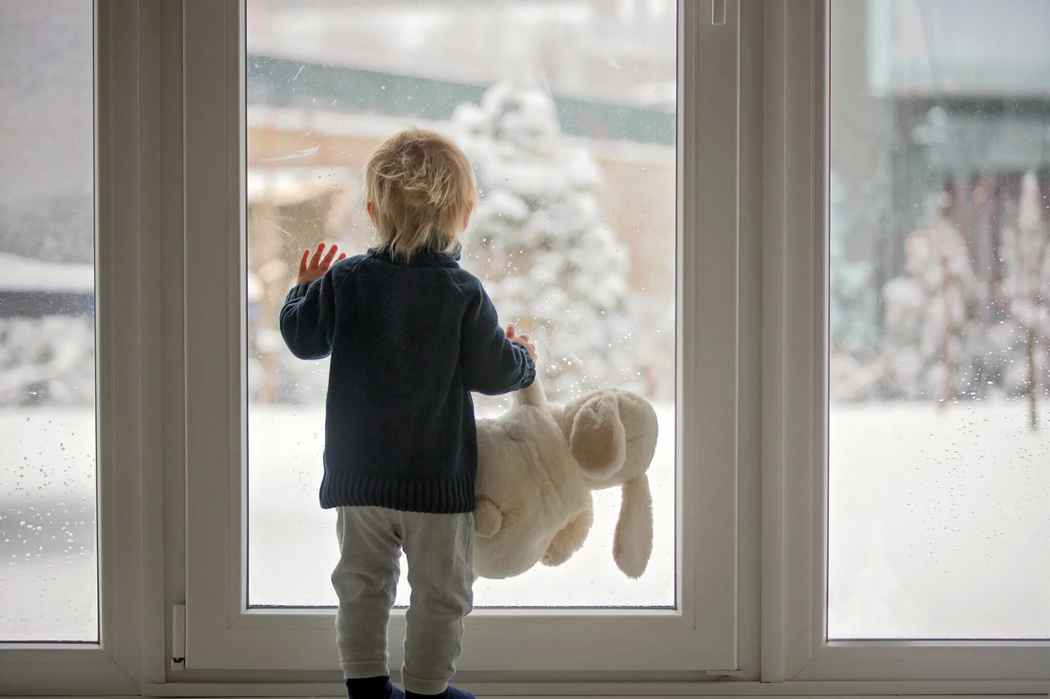 Ребенок у окна зимой. Зимнее окно для детей. Ребенок на подоконнике зимой. Зима за окном для детей.
