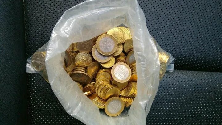 Девочка протянула продавцу горстку монет. Мешок с монетами. пакетик с мелочью. горсть монет. мешочек для мелочи.