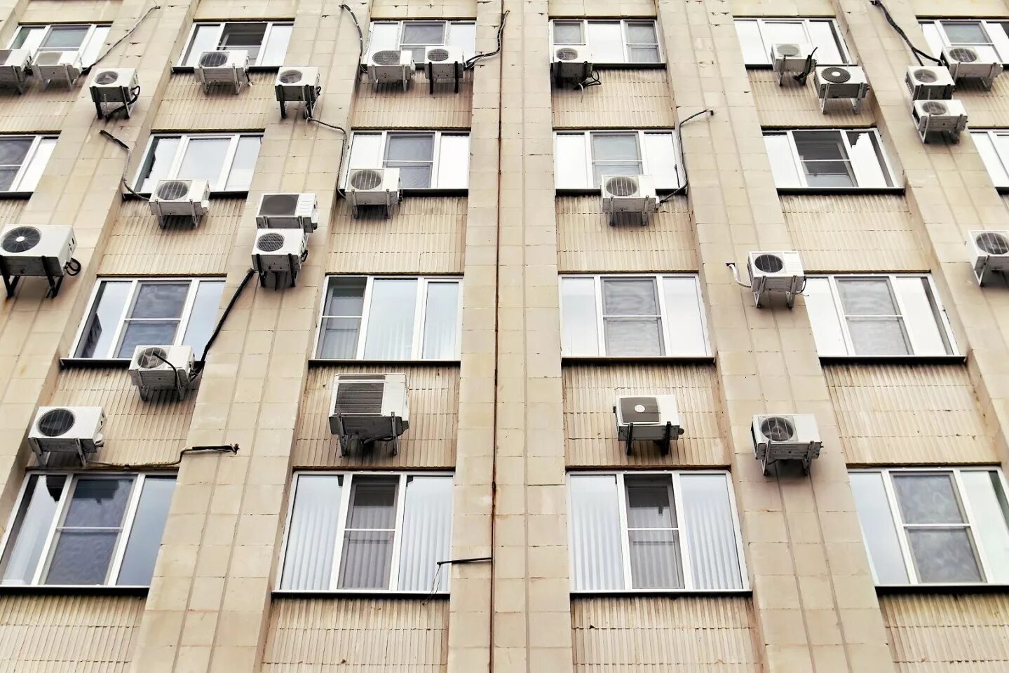 Кондиционеры на фасаде многоквартирного дома. Кондиционер на фасаде дома. Кондиционеры на фасаде здания. Кондиционер на фасаде. Наружные блоки кондиционеров на фасаде.