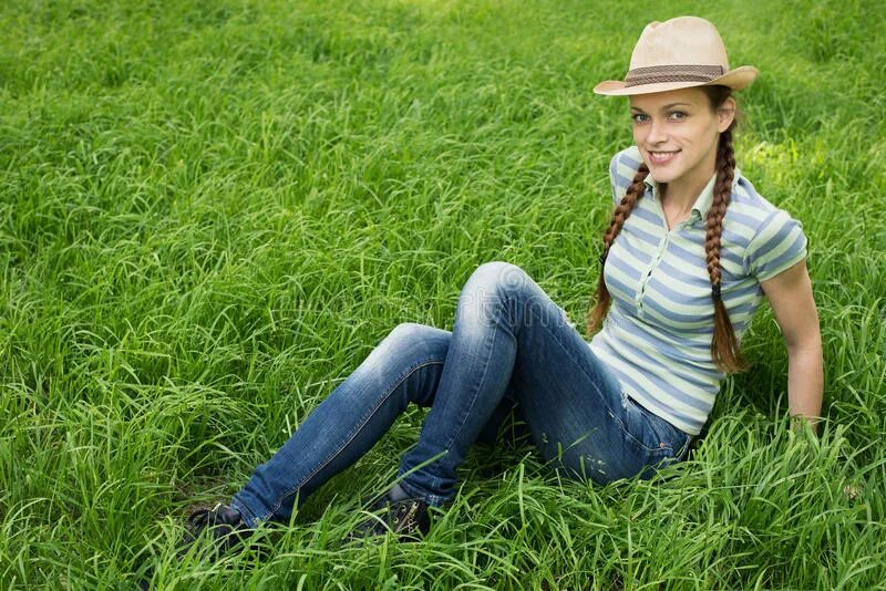 Тема молодая. Девочка сидит на траве. Девушка в джинсах сидит на траве. Молодая девушка в траве. Девушка на травке сидит.