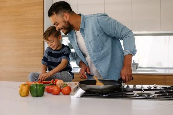 Дочки дают отцам на кухне после приготовления пищи