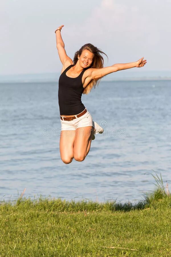 Молодая девушка прыгает. Девчонки летом подпрыгивают. Женщина прыгает. Молодая девушка прыгает. Прыжок купальник.