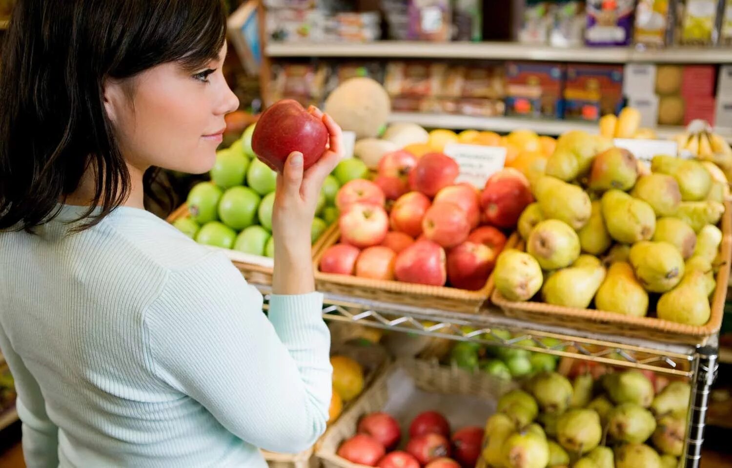 Женщина на рынке выбирает овощи. Яблоко магазин. Овощи и фрукты. Девушка в овощном магазине.