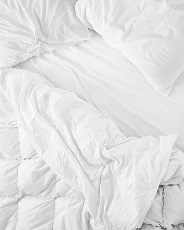 Смятая белая постель. Смятая простынь. Скомканное одеяло. Кровать сверху. Белое Мятое постельное белье.
