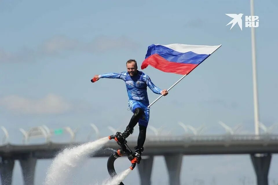 12 июня мужчина. Спортсмен поднимающий флаг. Парафойл российский флаг. Флайборд с флагом России.