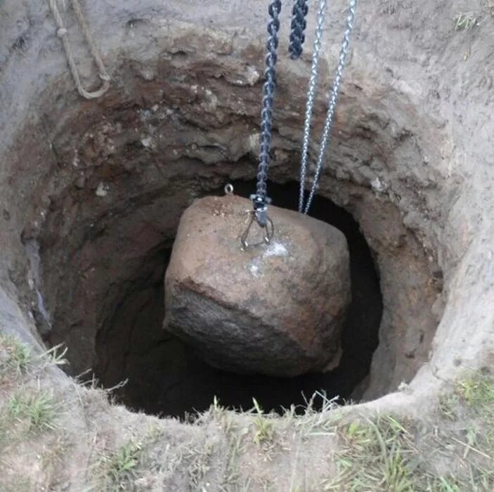 Вытащить камень из земли. Арматурина торит из земли. Копаем колодцы. Вытаскивают камни из котлована. Ручная копка колодцев.