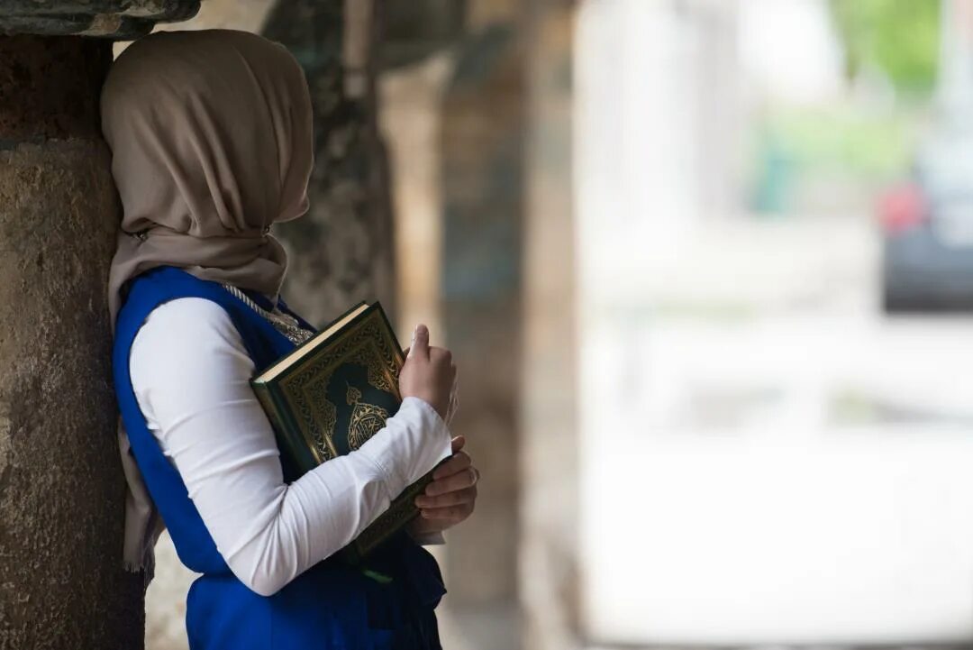 Мусульманин читающий коран. Мусульманка. Мусульманка и Коран. Мусульманка в платке с Кораном. Мусульманские женщины.