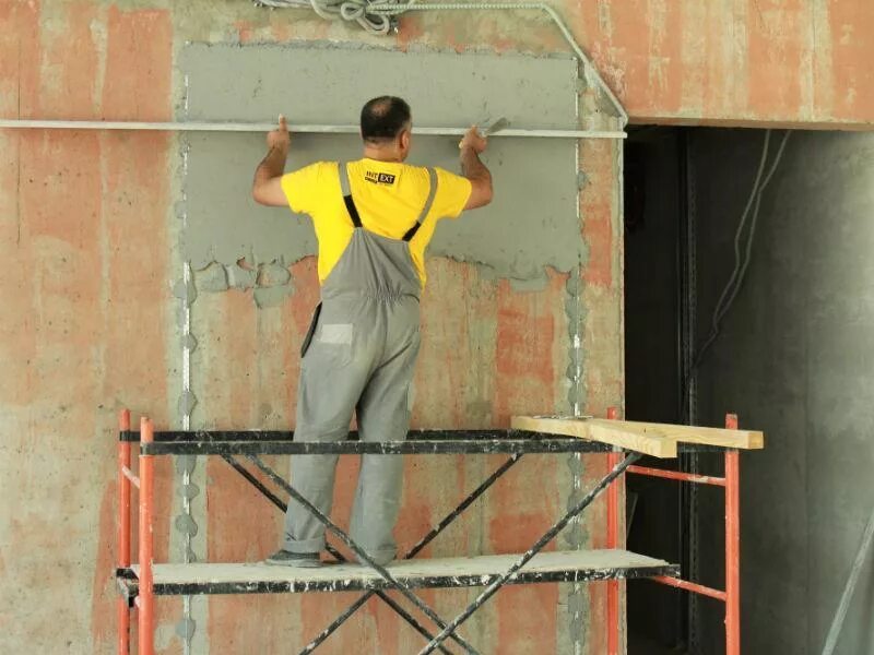 маляр. покраска фасада альпинистами. штукатурные работы высоте. цементная штукатурка на фасаде. высококачественная штукатурка стен.