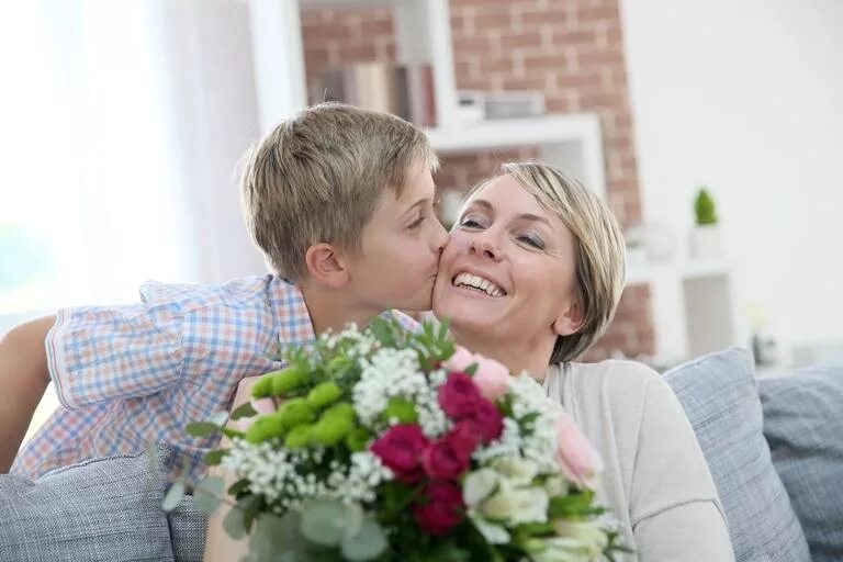 Мальчик целует маму. Сын дарит маме цветы. Мальчик дарит цветы маме. Мальчик дарит цветы маме фото.