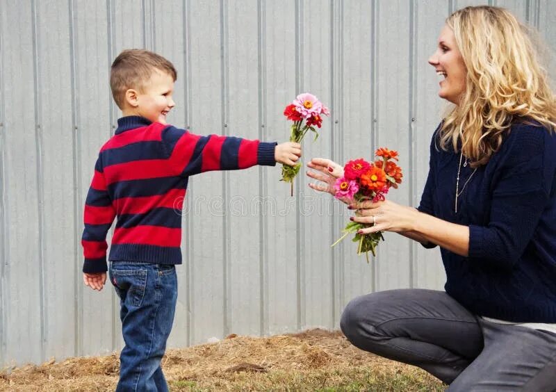 Мальчик дарит цветы маме. Маме дарят цветы. Ребенок дарит цветы маме. Сын дарит маме цветы.