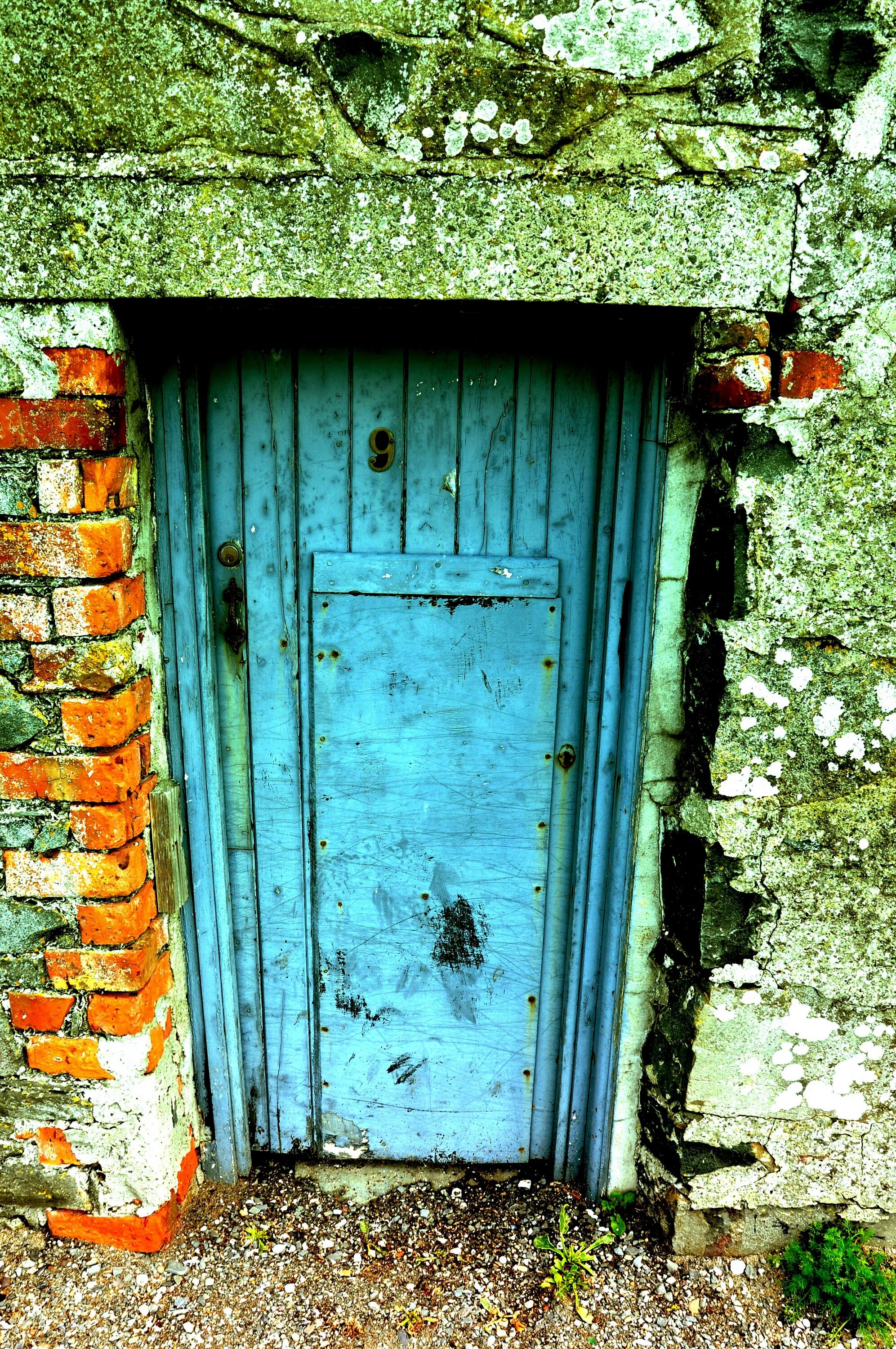 Откройте дверь руин. Кирпичная стена с дверью. Синие старинные двери. Двери на кирпичный сарай. Синяя дверь на кирпичной стене.