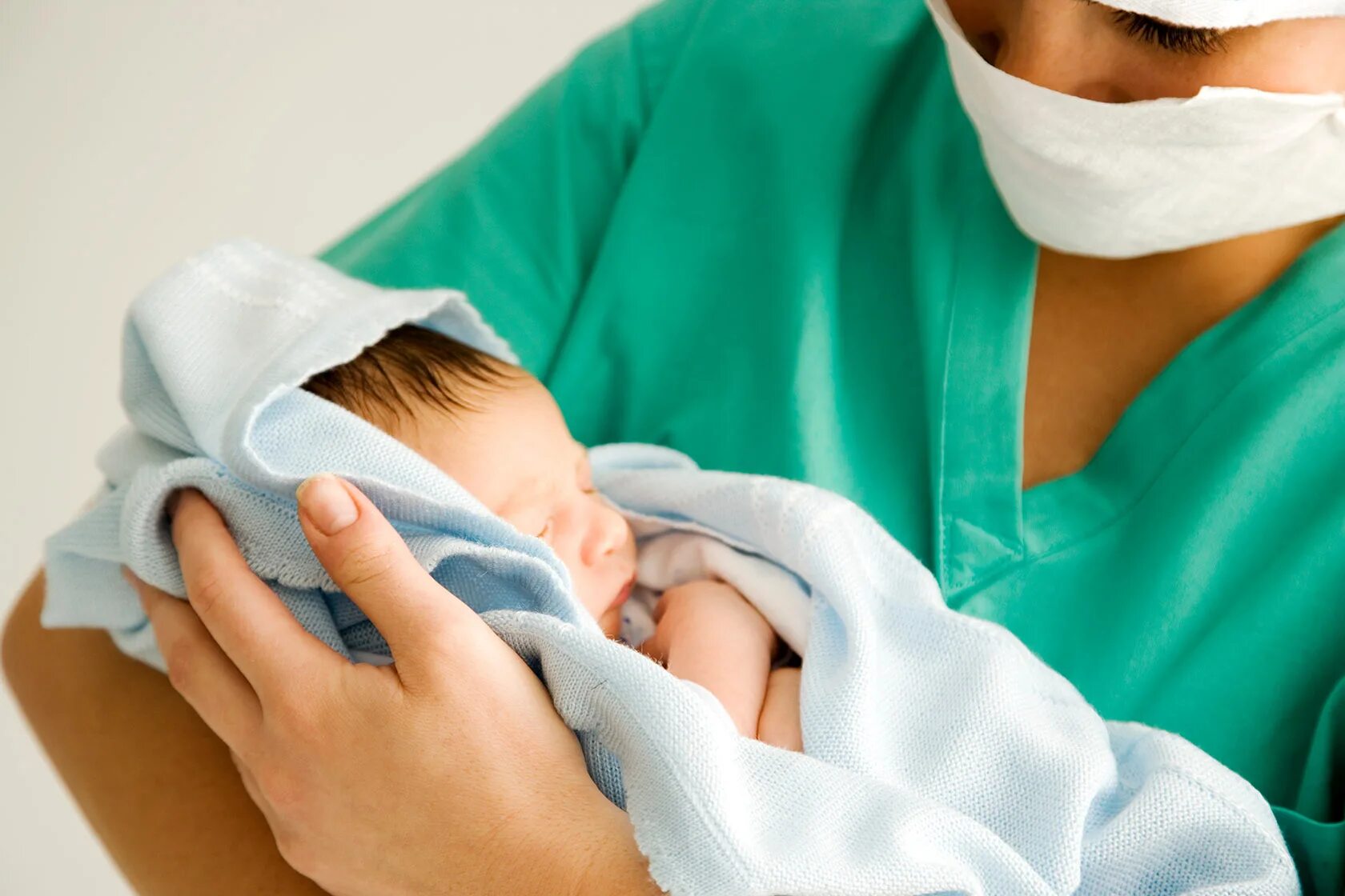 Рожала без врачей. Младенец на руках у акушерки. Акушерка с новорожденным. Медсестра и новорожденный.
