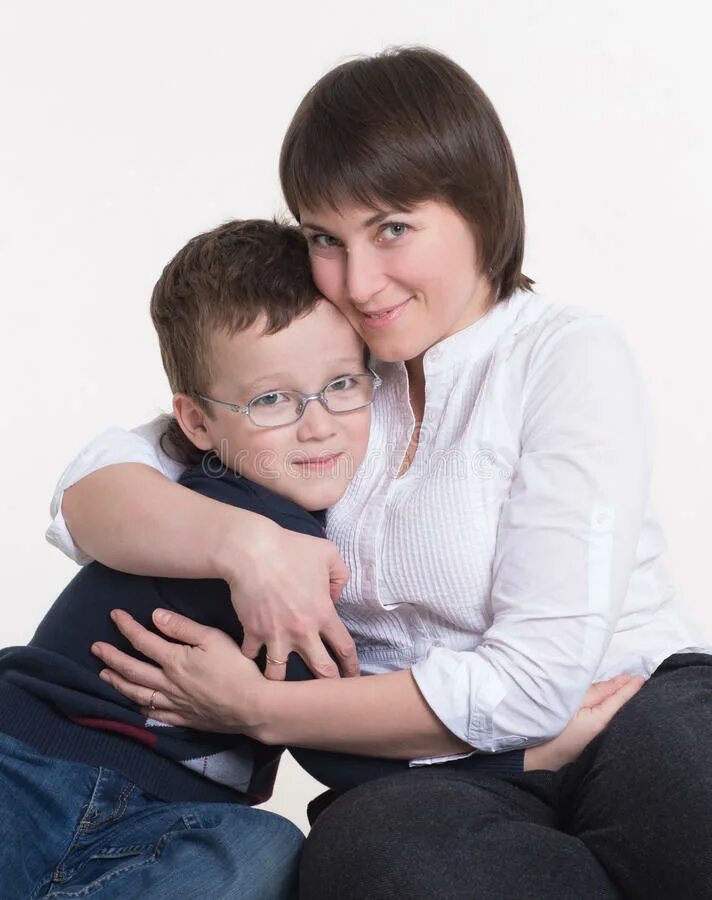 Молодая русская мамка с сыном. Мама обнимает сына. Сын обнимает свою маму. Мама обнимает старшего сына. Мать обнимает сына на диване.