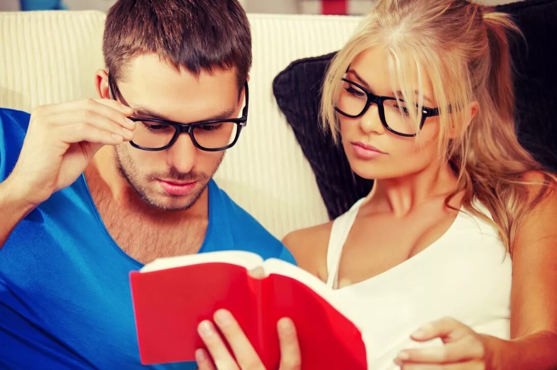 Родители выбирают имя ребенку. Парочка читает книгу. Парень и девушка читают книгу. Девушка и мужчина в кресле. Пара чтение.
