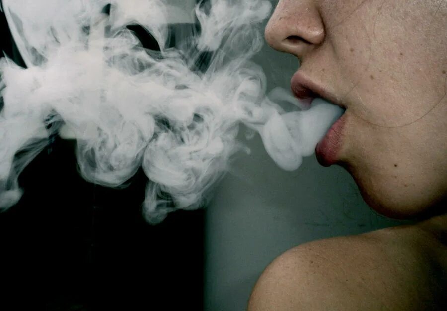 Дым изо рта. Выдыхает дым. Выдох дыма. Выдыхает сигаретный дым. Вместе с дымом сигарет