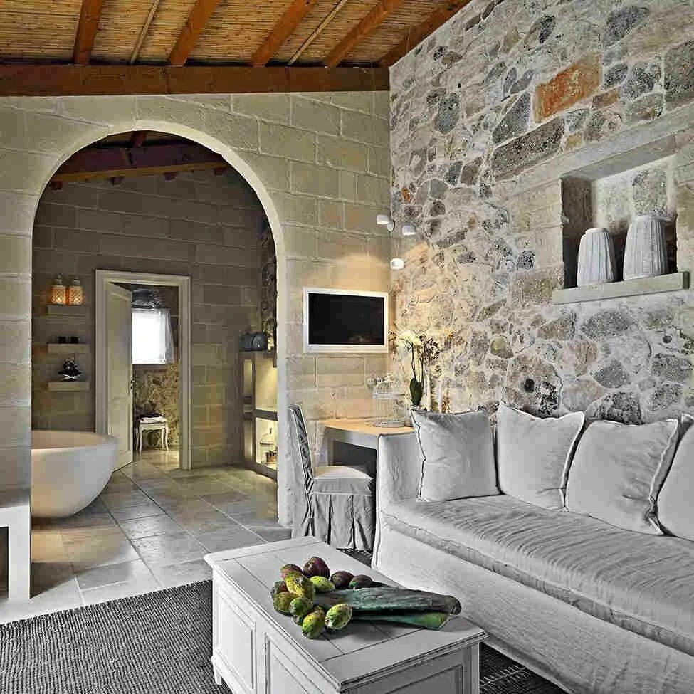 Стиль стоун. Штукатурка Мазанка Прованс. Итальянский стиль в интерьере. Стена из камня в интерьере. Каменный дом интерьер.