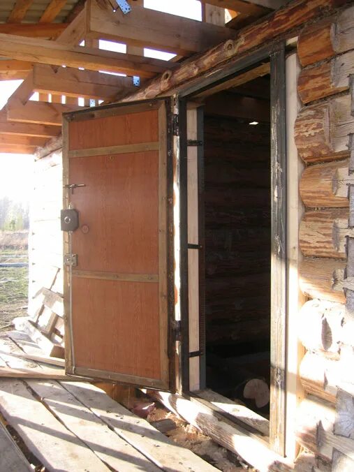 Двери в деревянном доме. Металлическая дверь в деревянный проем. Установленная входная дверь в дом. Монтаж входной двери в деревянном доме. Железная дверь в деревянном доме