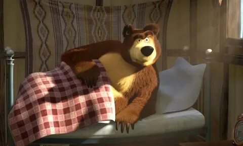 The green bear is on the bed