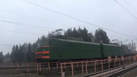 Электровоз с грузовым поездом приветливый машинист