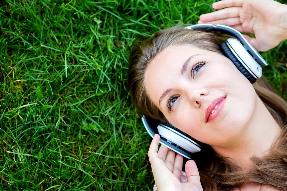 She listen to the radio. Женщина в наушниках. Человек в наушниках. Человек с наушниками. Девушка в наушниках на природе.