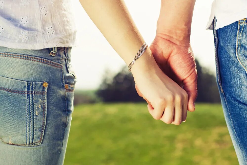 держатся за руки. схватившиеся руки. люди держатся за руки сзади. держатся за руки. брать другого за руку.