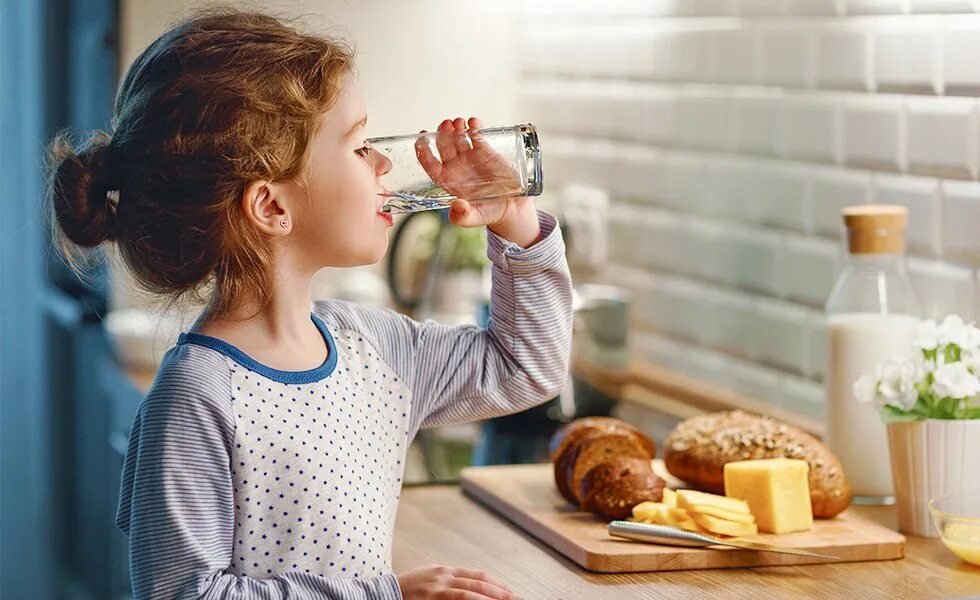 Ребенок пьет воду. Девочка пьет воду. Пища и питие дети. Девушка пьет воду на кухне.