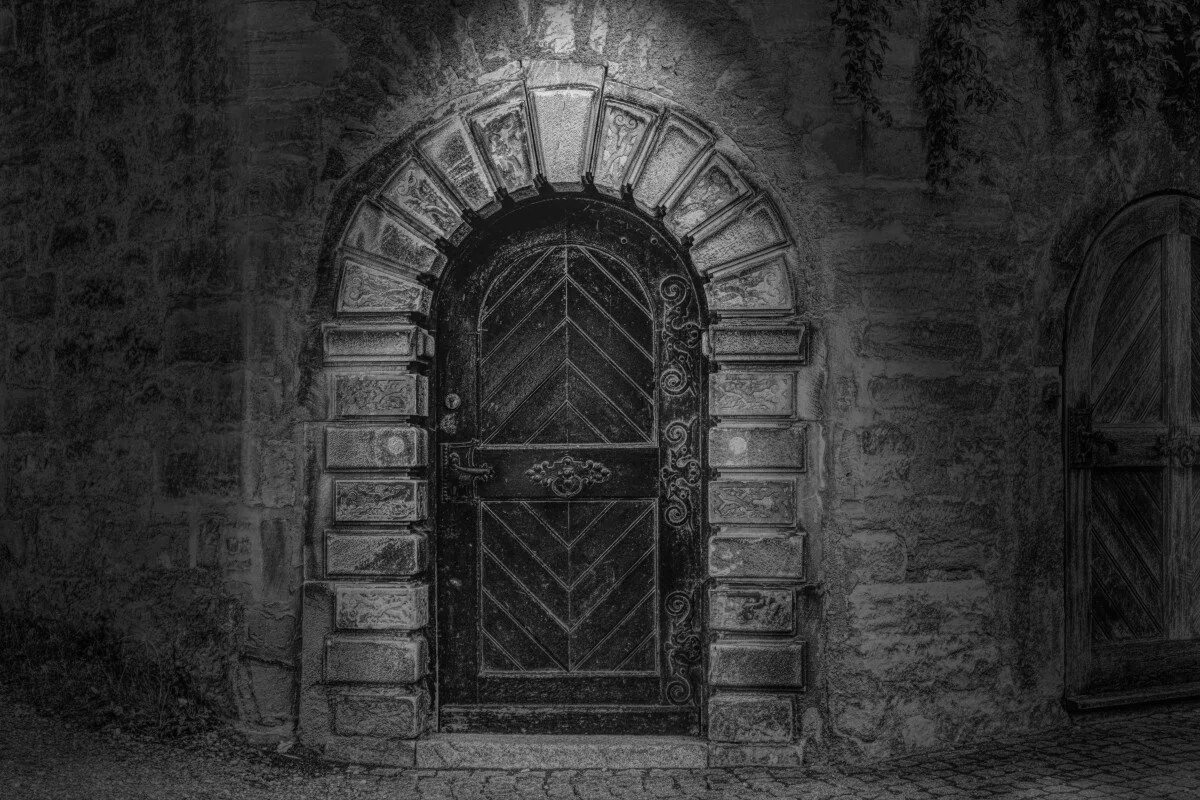 Темная арка. Готические ворота. Ворота средневекового замка. Замок для двери. Старинные ворота.