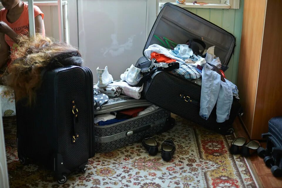 Распаковываем чемоданы. Собранные чемоданы с вещами. чемоданы с вещами в комнате. собранный чемодан с вещами. разобранный чемодан.