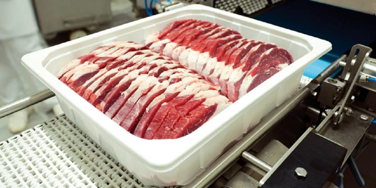 Движение полуфабрикатов. Упаковка мяса в лотки. изготовитель мясных полуфабрикатов. газовые упаковки мяса. цех мясных полуфабрикатов.