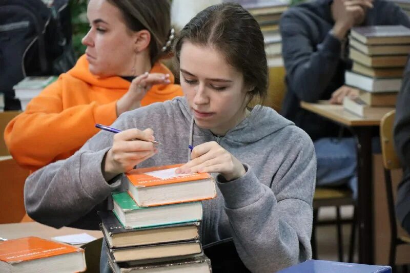 книга человек. студенты в библиотеке. имит петргу. студент с учебниками. читатели в библиотеке.