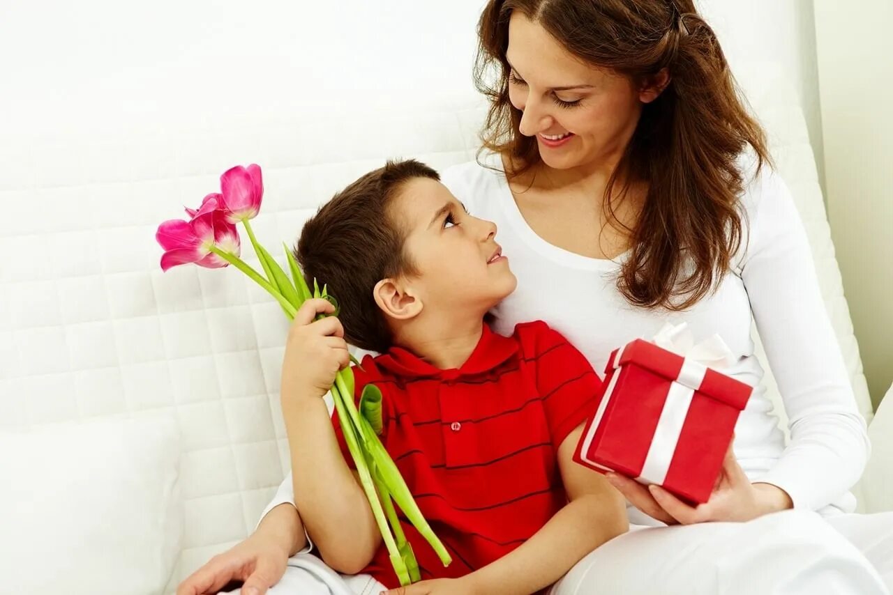Ребенок дарит цветы маме. Ребенок дарит подарок маме. День матери. Дети поздравляют маму.