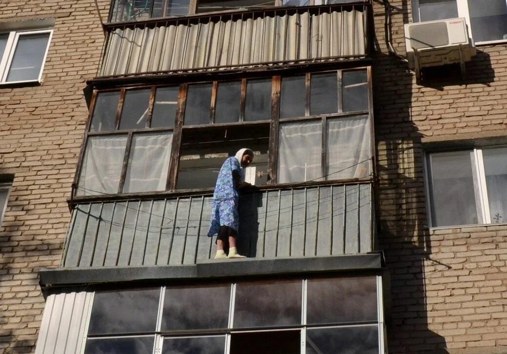 Многоэтажка с балконами. Женщина на балконе. Кричит с балкона.