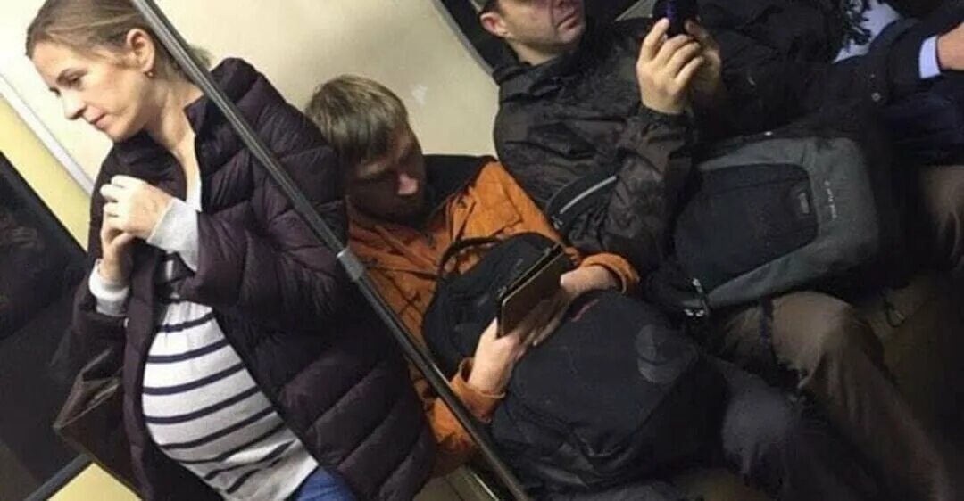 Мужчина и женщина в метро. Мужчина уступает место женщине в транспорте. Домогательства в общественном транспорте.