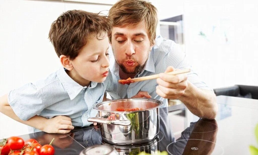 Дочки дают отцам на кухне после приготовления пищи