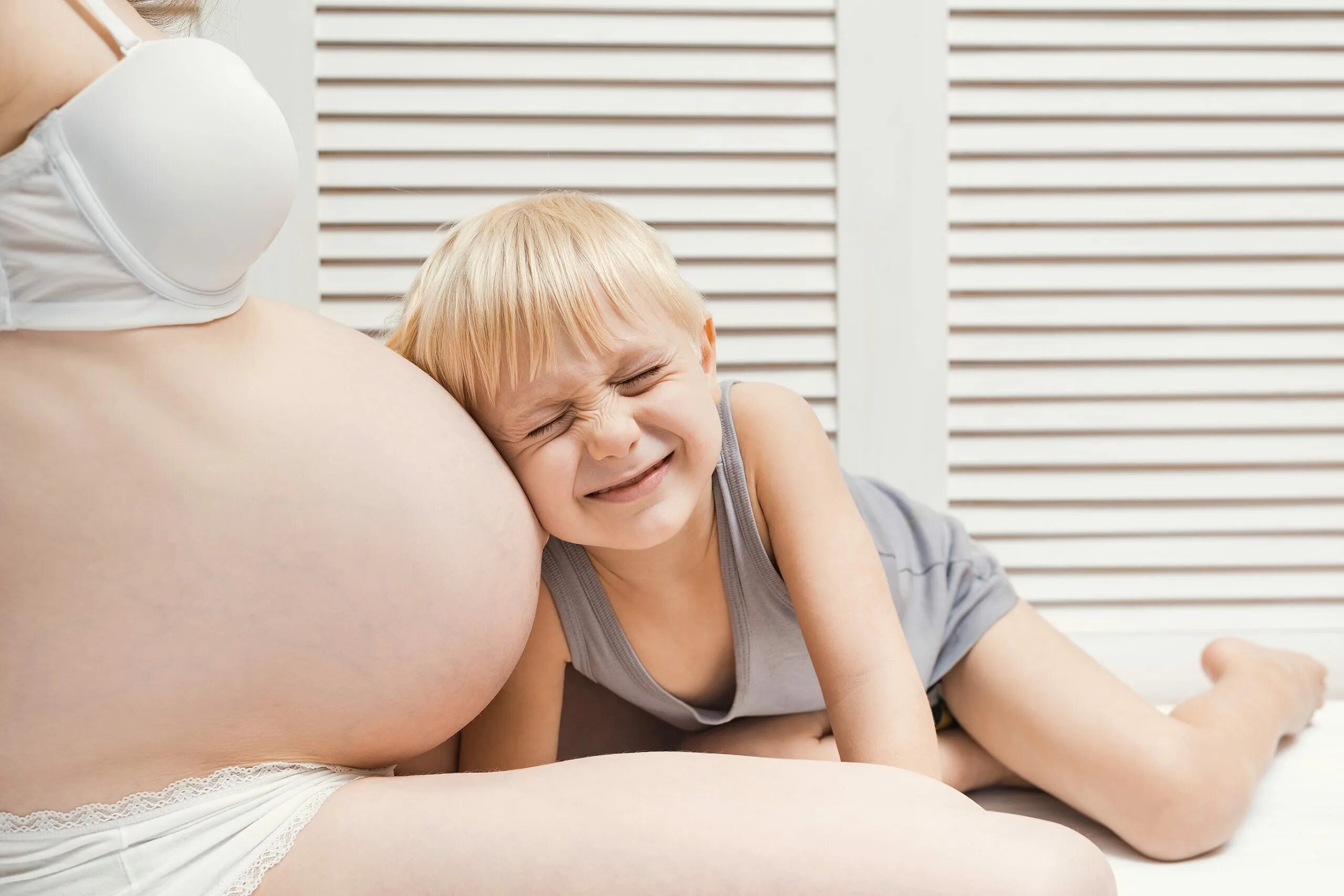 Беременность вторым мальчиком. Ухо к беременному животу. Малыш слушает живот беременной мамы. Ребенок слушает мамин беременный живот. Мама которая показывает беременный живот детям.