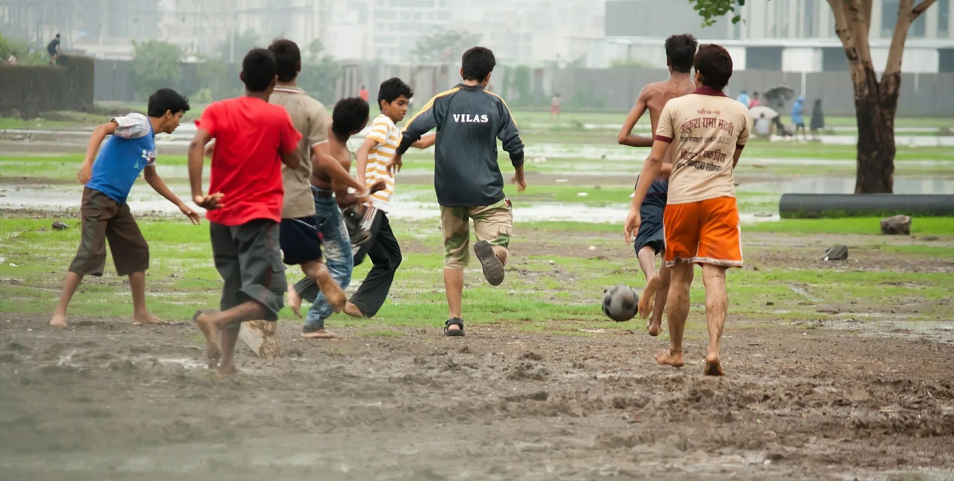 Игры в дождь в лагере. Футбол под дождем. Мальчик. Фото мальчик играет в футбол.