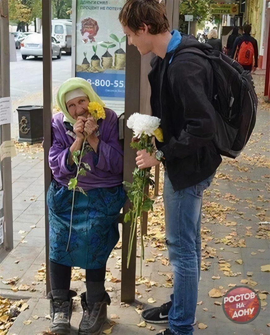 Делаем добро другим людям. Бабушке дарят цветы. Добрые поступки людей. Люди добрые. Бабушке дарят цветы на улице.