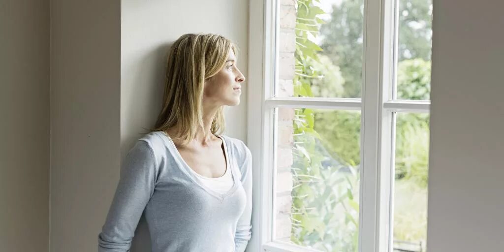 The woman at the Window. Woman looking at Window.