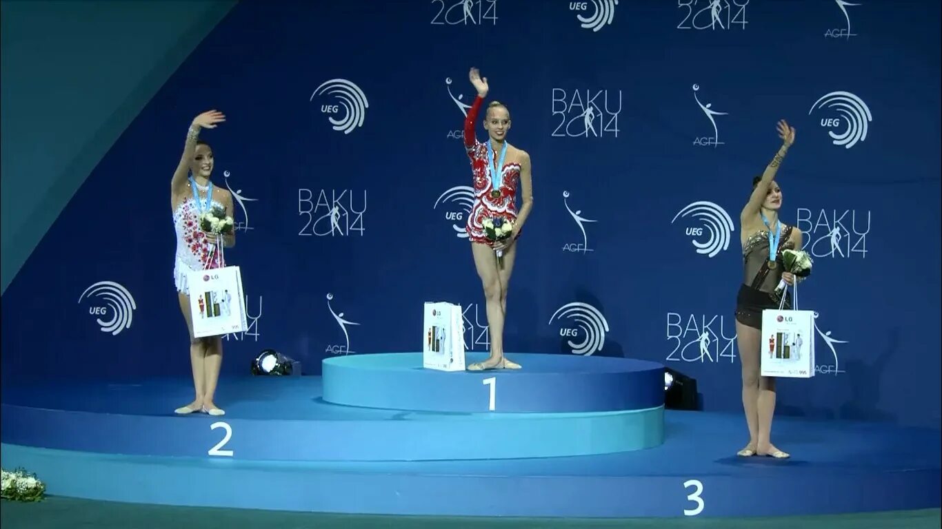 солдатова аверина лала крамаренко. гимнастка стоит. пьедестал почета гимнасток. спортивный подиум. гимнастки на пьедестале.