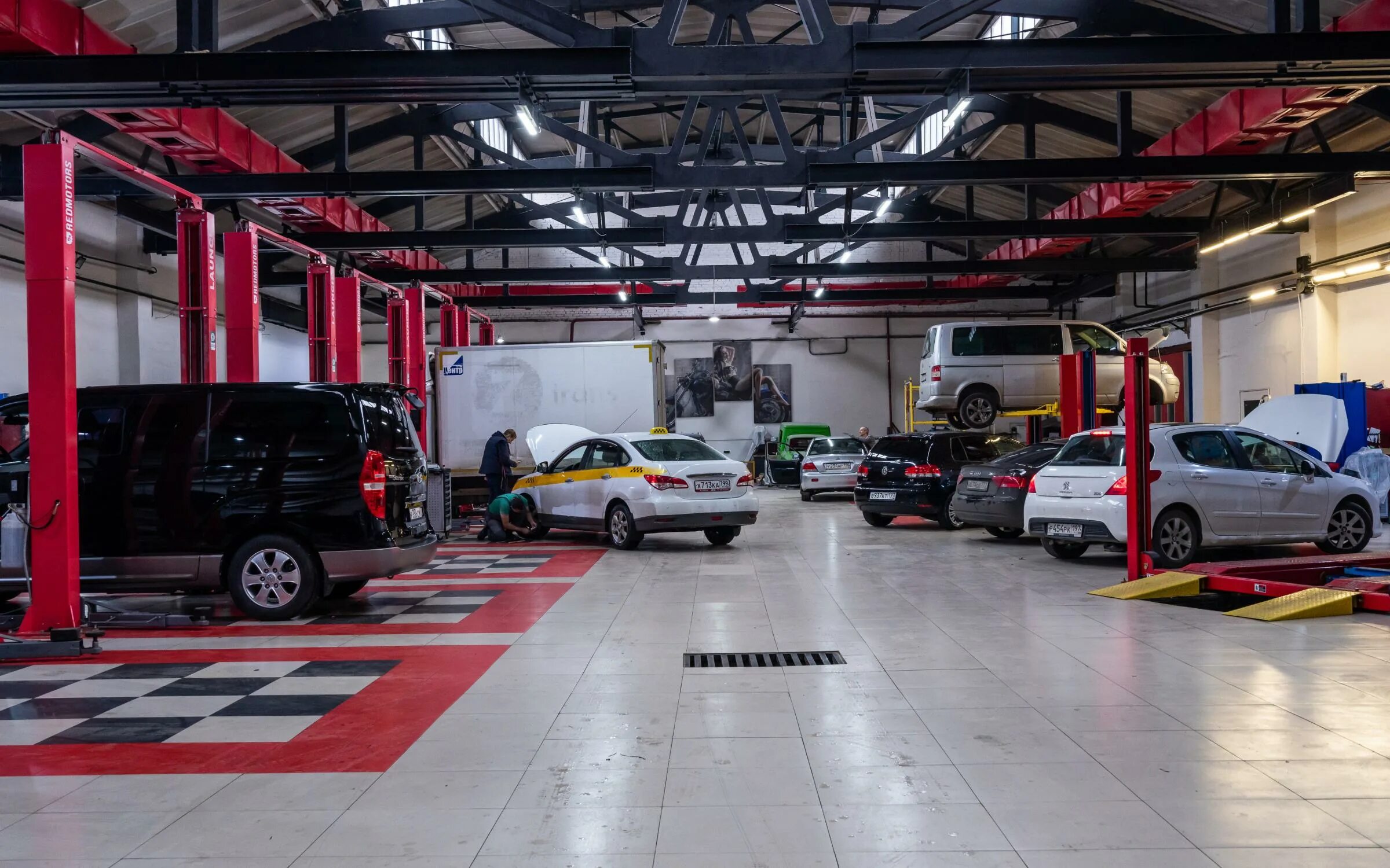 Станция техобслуживания автомобилей. Машина на подъемнике. Машина в автомастерской. Машина на подъемнике. Техническое обслуживание автомобиля.