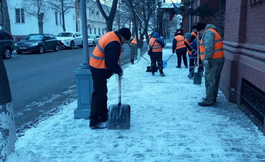 День коммунальных служб. Работники ЖКХ убирают снег. Зима без снега. Техника расчистки тротуаров от льда. Пешеход на тротуаре.