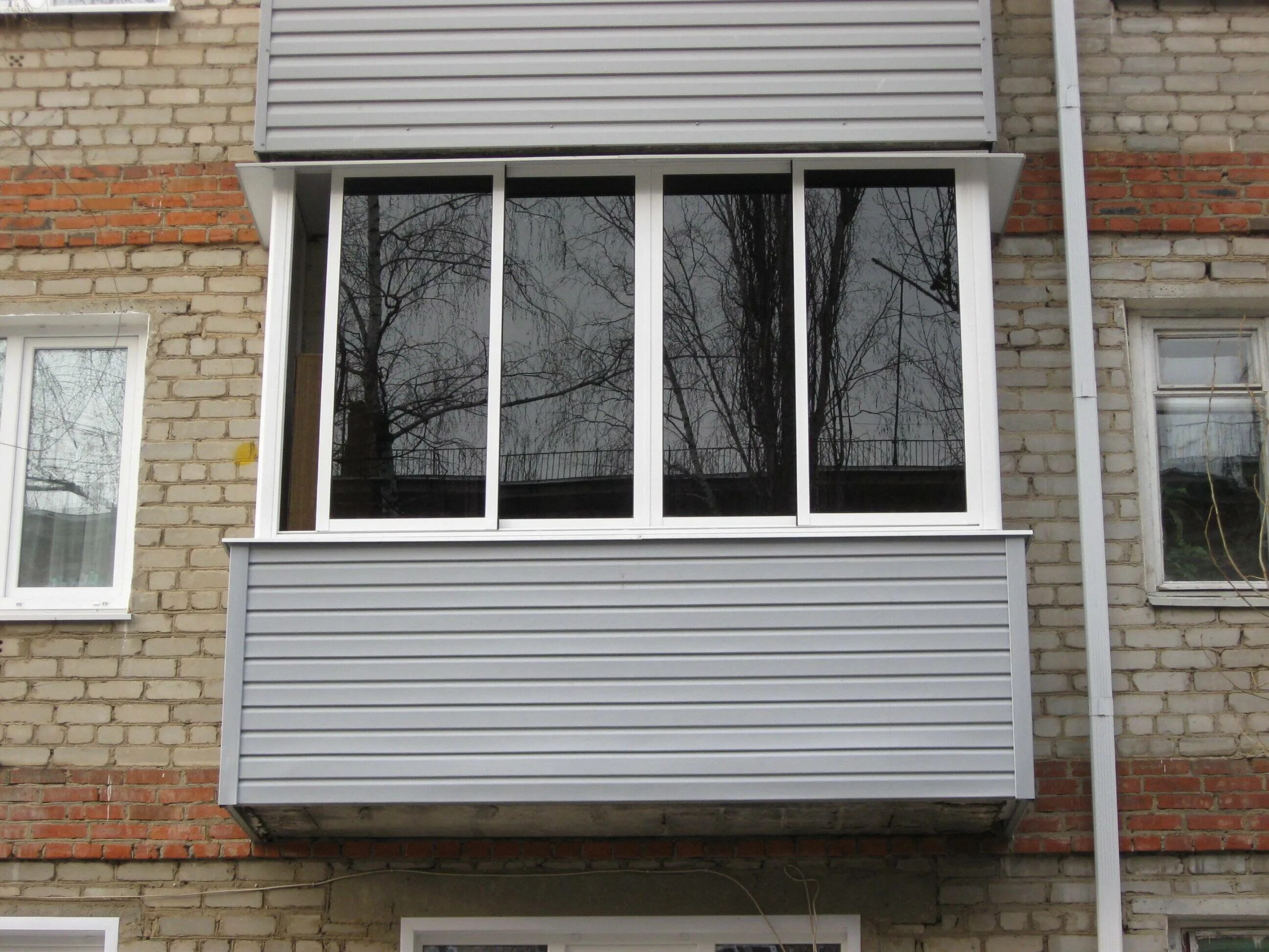 Пластиковый балкон. Внешняя отделка балкона. Сайдинг для наружной отделки балкона. Тонированные окна на балконе.