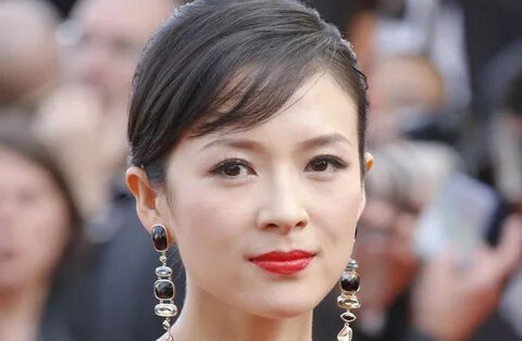 Қара қыздың қарынға дейін ілінетін үлкен сиськи бар.