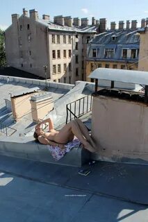 Голая девушка на крыше дома.