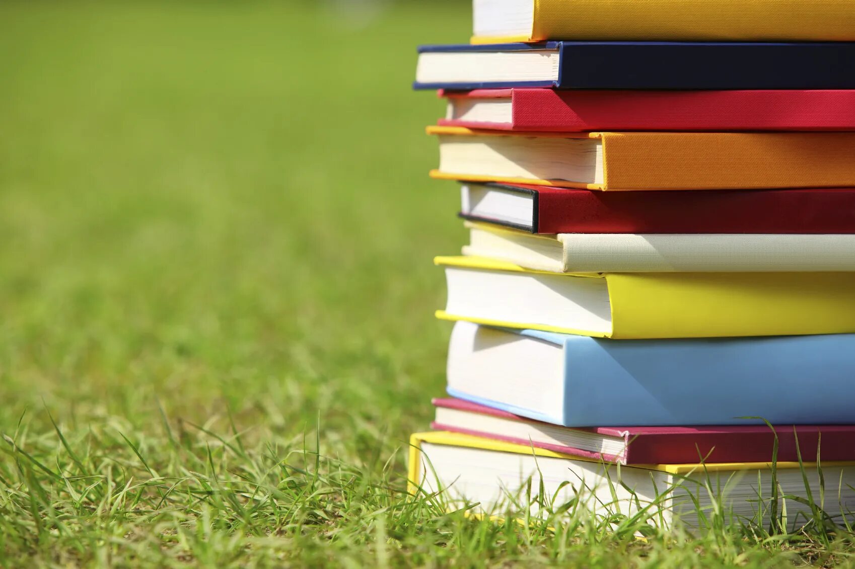 Проект год книги. Стопка книг. Яркие книги. Книга на траве. Украинские учебники.