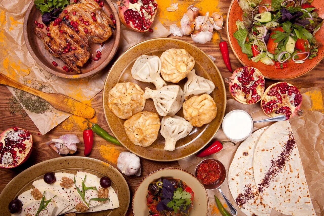 Грузинские блюда на столе. Восточно европейская кухня. Хинкали и хачапури. Грузия - традиционное грузинское застолье супра. Грузинская кухня.