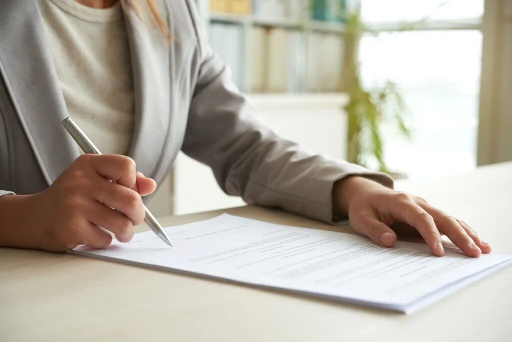 Женщина подписывает бумаги. Оформление документов. Договор на столе. Document signing. Рука подписывает документ.